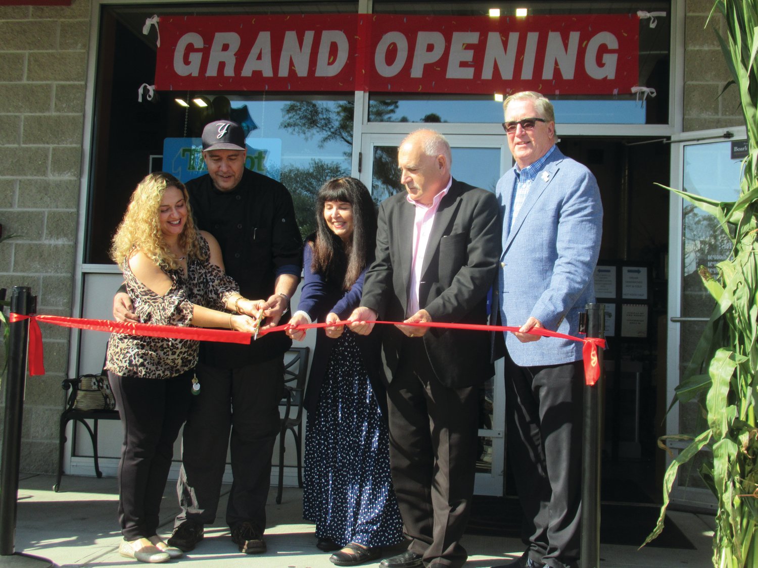 OFFICIAL OPENING: Jeff and Kim Paquette, assisted by Johnston Mayor Joseph Polisena, Cranston Mayor Ken Hopkins and Elaine Paquette make it official during Monday’s grand opening/ribbing cutting of Heaven and Earth Catering at Schroder’s Deli, 1302 Atwood Ave.